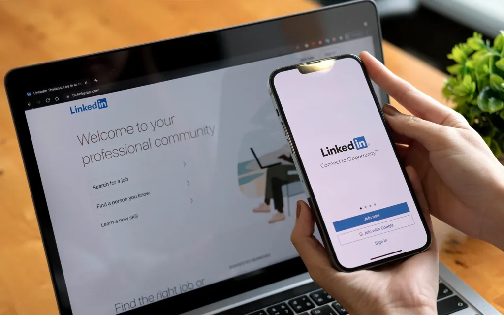 a woman holds apple iphone with linkedin application on the screen